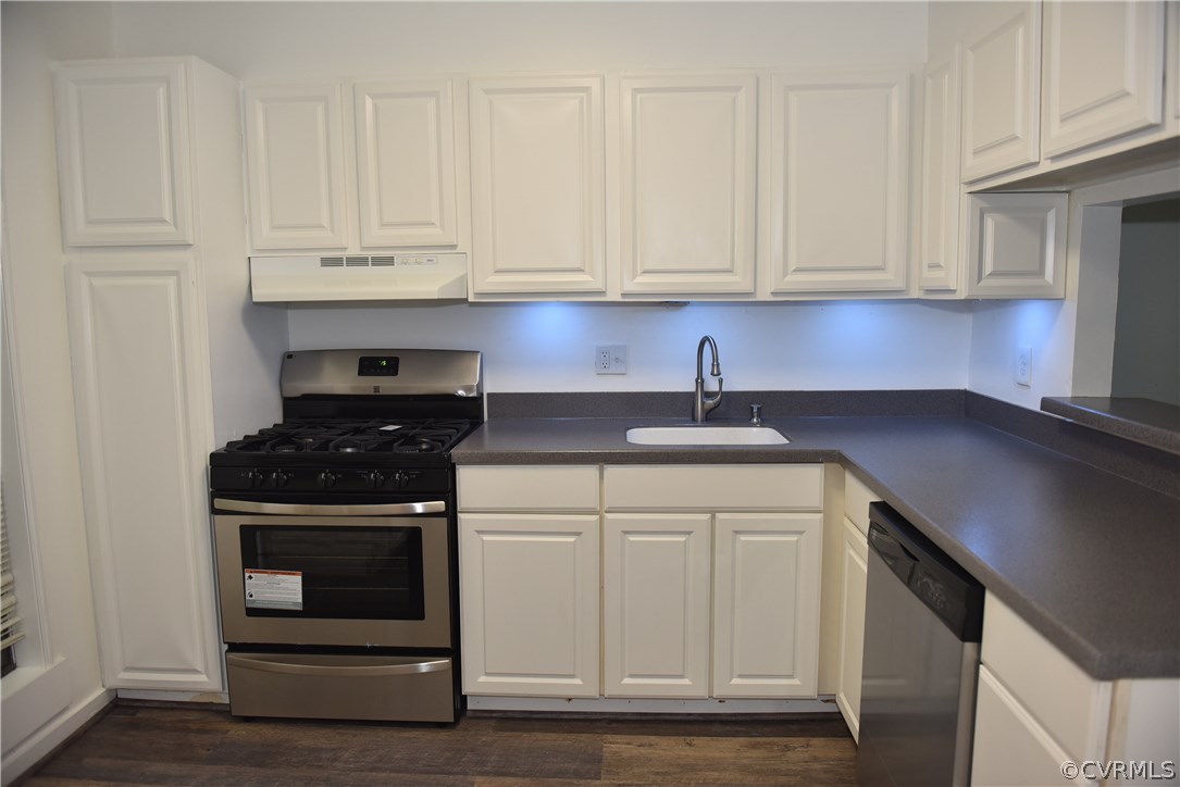 a kitchen with granite countertop white cabinets and white appliances
