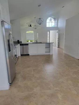 a view of a kitchen with a sink refrigerator and window