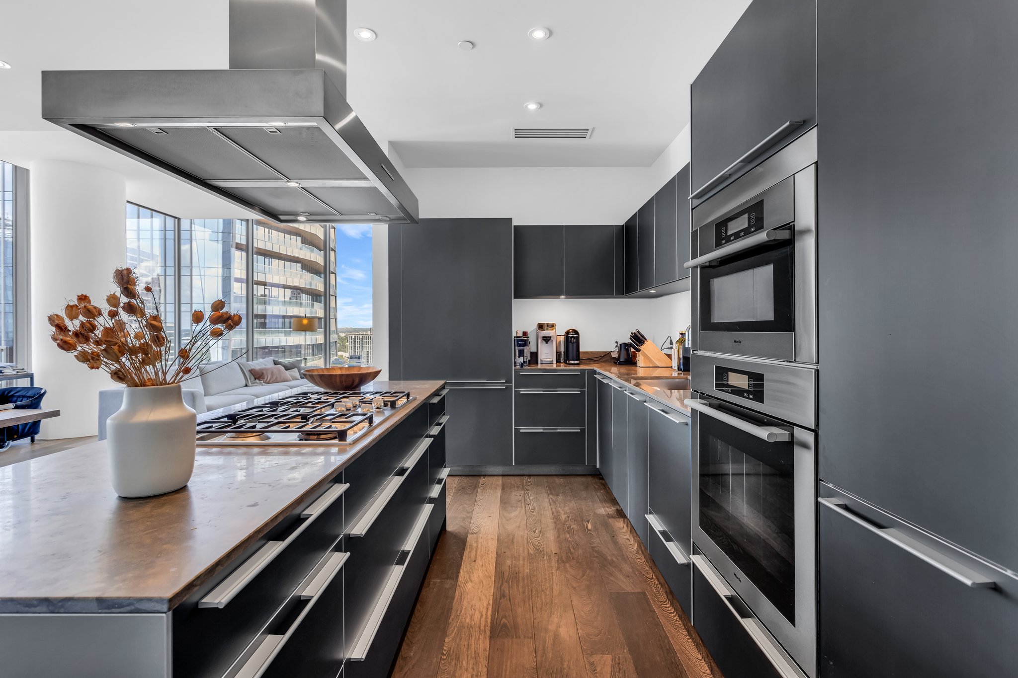 210 Lavaca Street, Unit 2308 Austin, TX 78701 - Photo 11 of 40 a kitchen with stainless steel appliances granite countertop a stove top oven a sink dishwasher a dining table and chairs with wooden floor