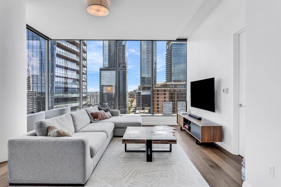 210 Lavaca Street, Unit 2308 Austin, TX 78701 - Photo 15 of 37 Living room with floor to ceiling windows, wood finished floors, and a wealth of natural light