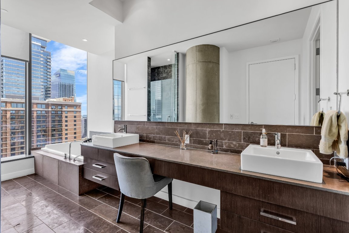 210 Lavaca Street, Unit 2308 Austin, TX 78701 - Photo 18 of 37 Bathroom with lots of natural light, double vanity, a soaking tub, a shower, and a city view