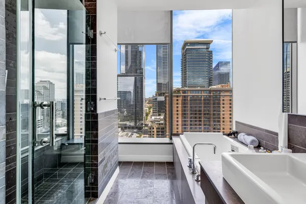a bathroom with a tub sink and glass door