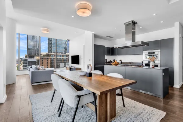 a open dining room with stainless steel appliances kitchen island granite countertop a table chairs a sink and a refrigerator