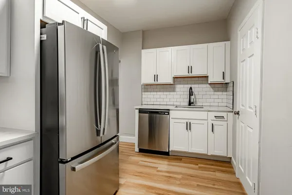 a kitchen with white cabinets and stainless steel appliances