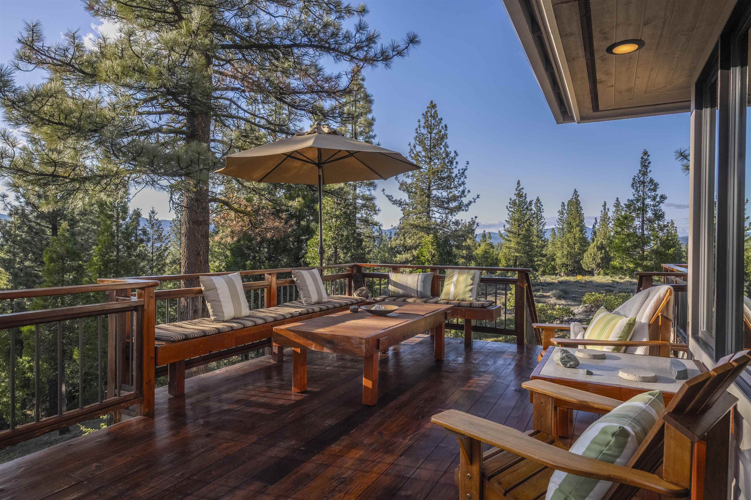 238 Clouds Rest Portola, CA 96122 - Photo 9 of 34 a view of a patio with table and chairs under an umbrella with wooden floor