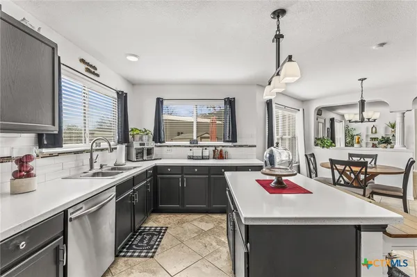a kitchen with a sink a stove and chairs