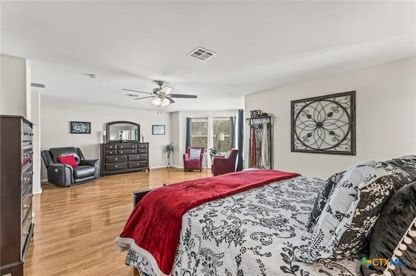 a bedroom with bed and wooden floor