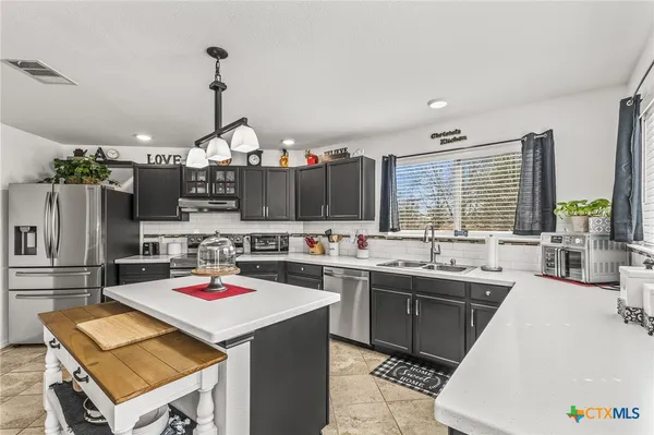 a kitchen with a sink a stove and cabinets