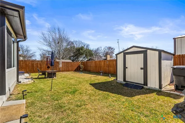 a backyard of a house with table and chairs