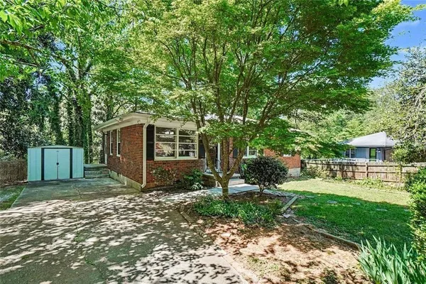 a view of a backyard with table and chairs and a large tree