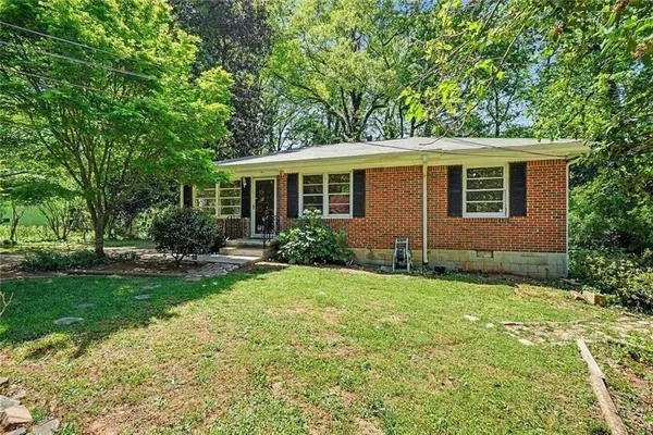 a view of backyard of house with green space