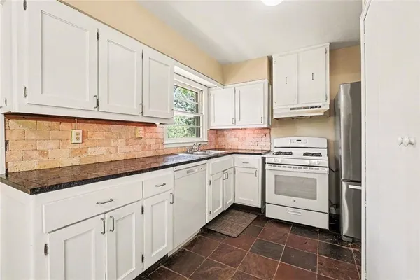 a kitchen with granite countertop white cabinets and white appliances