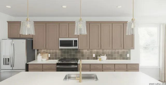 a kitchen with kitchen island granite countertop a sink a stove and a refrigerator