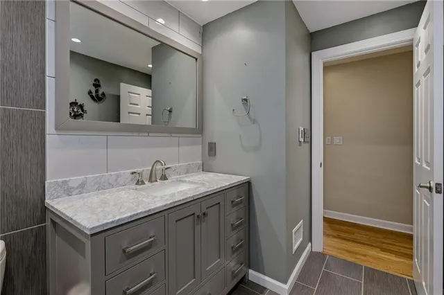 a bathroom with a granite countertop sink and a mirror