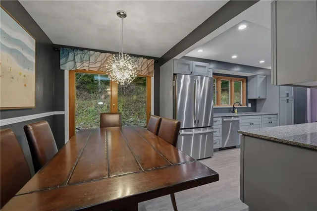 a living room with kitchen island furniture a flat screen tv and a large window