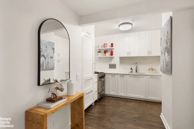a room with granite countertop a sink cabinets and wooden floor