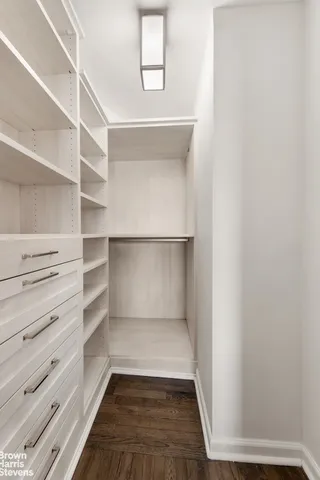 a view of walk in closet with empty racks