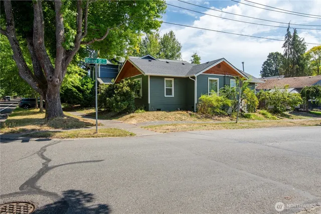 a front view of a house with a yard and potted plants