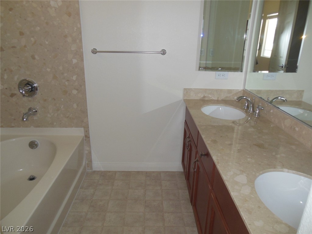 6390 Jackson Spring Road Las Vegas, NV 89118 - Photo 9 of 27 Luxurious dual vanities complement the deep soaking tub in this serene bath retreat.
