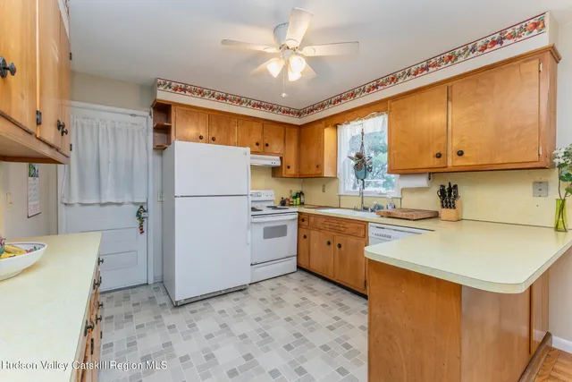 a kitchen with a refrigerator a stove a sink cabinets and a dining table