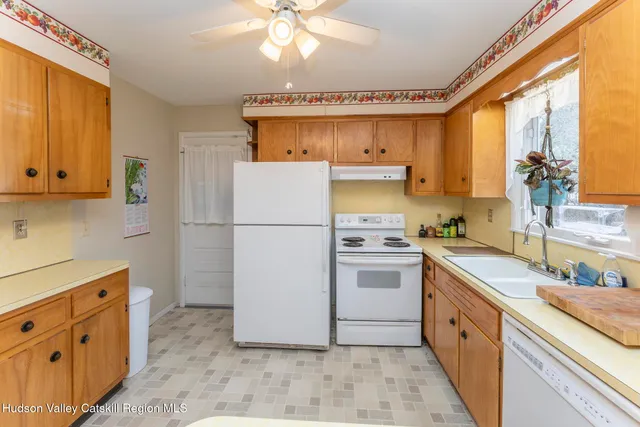 a kitchen with cabinets stainless steel appliances and a window