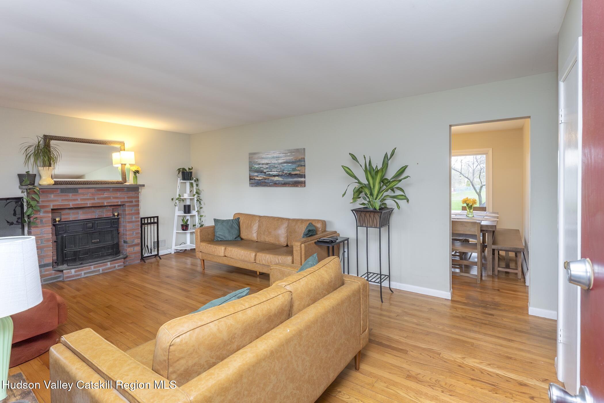 121 Rayna Street Hurley, NY 12443 - Photo 3 of 41 a living room with furniture a fireplace and a table
