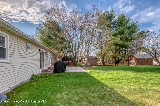 a yellow house with a big yard and large trees