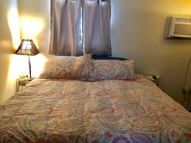 2234 Northeast Pine Ridge Street Jensen Beach, FL 34957 - Photo 4 of 16 a bedroom with a bed and a night stand