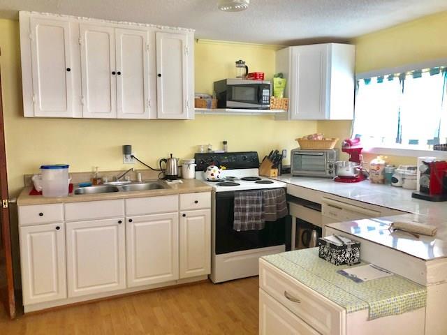 2234 Northeast Pine Ridge Street Jensen Beach, FL 34957 - Photo 8 of 16 a kitchen with stainless steel appliances a sink a stove and cabinets