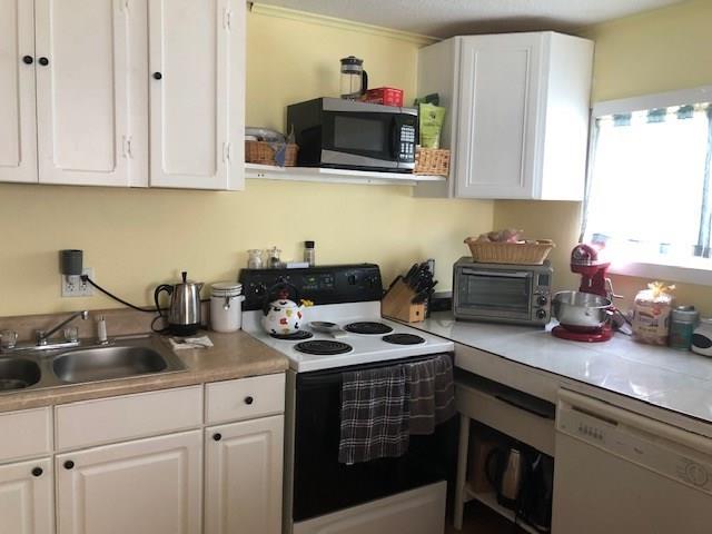 2234 Northeast Pine Ridge Street Jensen Beach, FL 34957 - Photo 9 of 16 a kitchen with stainless steel appliances granite countertop a sink a stove and a microwave