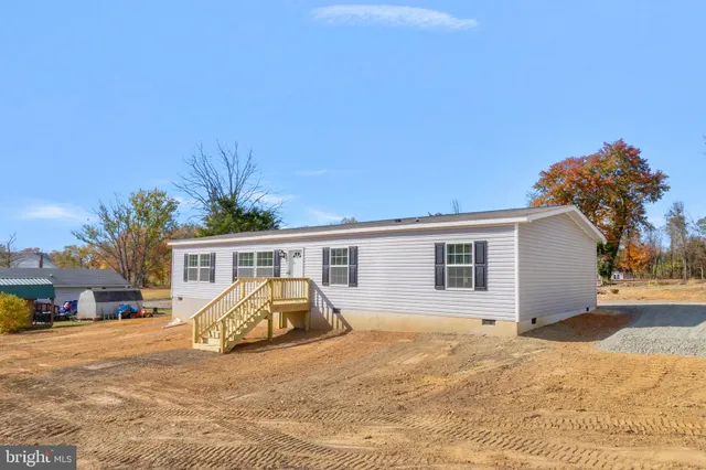 a front view of house with yard and trees in the background