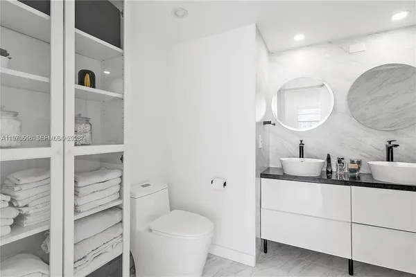 a bathroom with a toilet a sink and mirror