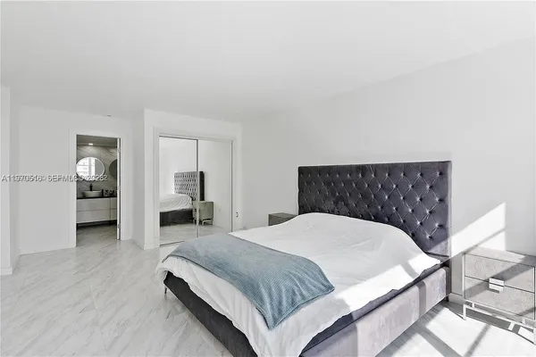 a spacious bedroom with a bed and a view of bathroom