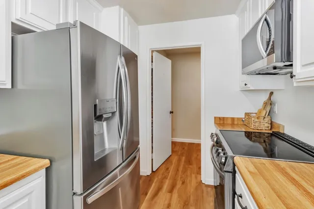 a kitchen with stainless steel appliances granite countertop a refrigerator and a sink