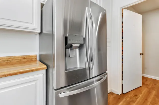 a metallic refrigerator freezer sitting in a kitchen