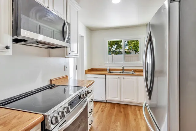 a kitchen with stainless steel appliances granite countertop a refrigerator and a sink