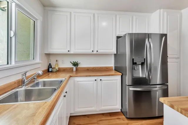 a kitchen with a refrigerator sink and cabinets