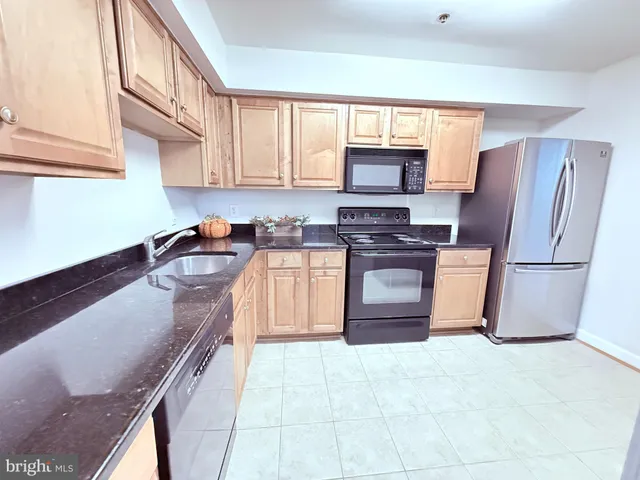 a kitchen with stainless steel appliances granite countertop a refrigerator stove top oven a sink and dishwasher