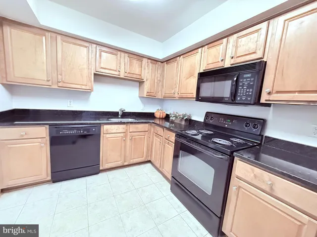 a kitchen with stainless steel appliances granite countertop a stove sink and cabinets