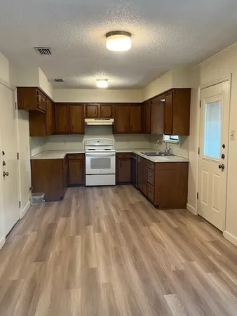 a large kitchen with kitchen island a sink stainless steel appliances and cabinets