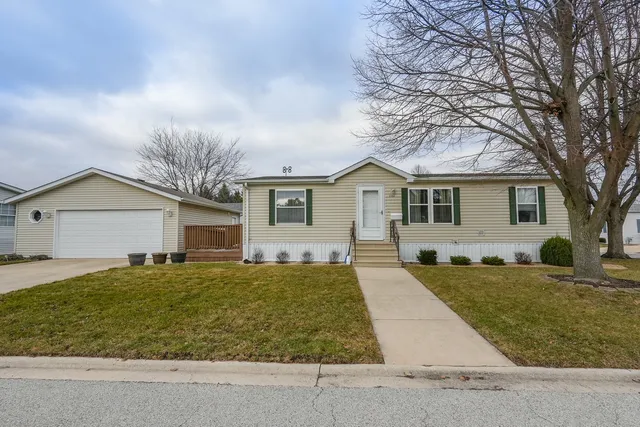 a front view of house with yard and trees in the background