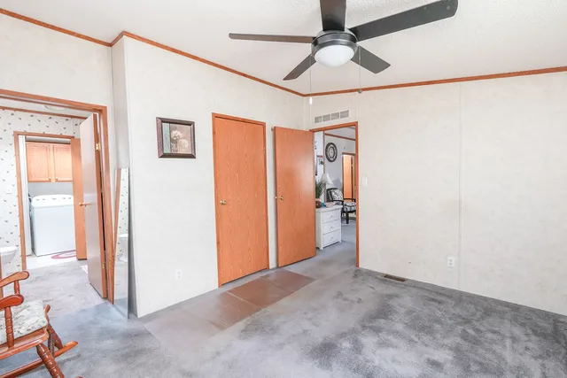 a view of a big room with wooden floor and a ceiling fan