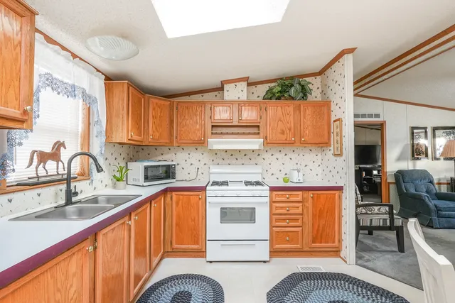 a kitchen with stainless steel appliances granite countertop a stove a sink and a microwave