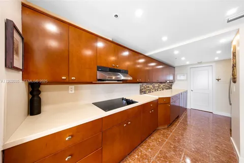 a kitchen with stainless steel appliances granite countertop a sink and a refrigerator
