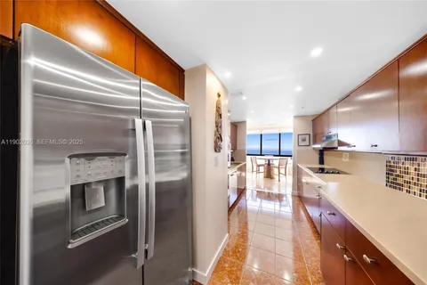 a kitchen with stainless steel appliances granite countertop a refrigerator a oven and white cabinets