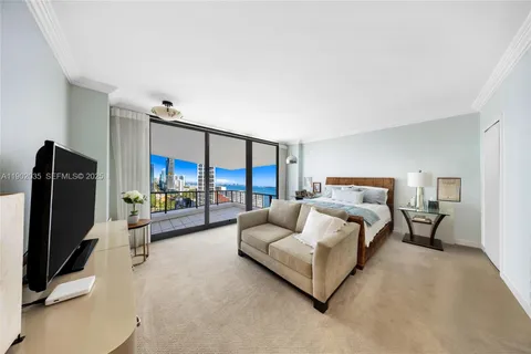 a spacious bedroom with a bed and a flat tv screen