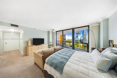 a large bedroom with a large bed and a flat screen tv