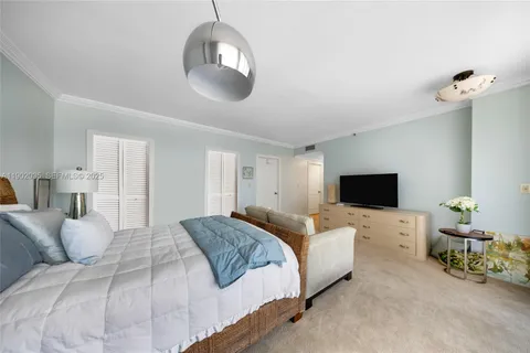 a spacious bedroom with a bed and a flat screen tv