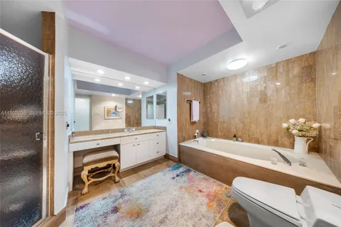 a bathroom with a tub sink and mirror