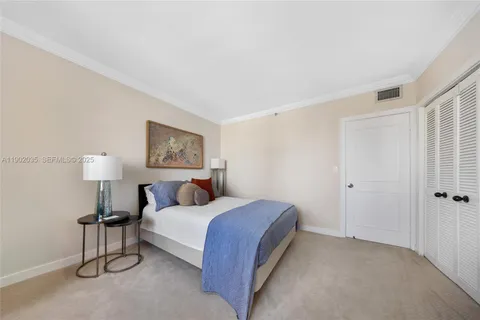 a bedroom with a bed and a lamp on the dresser